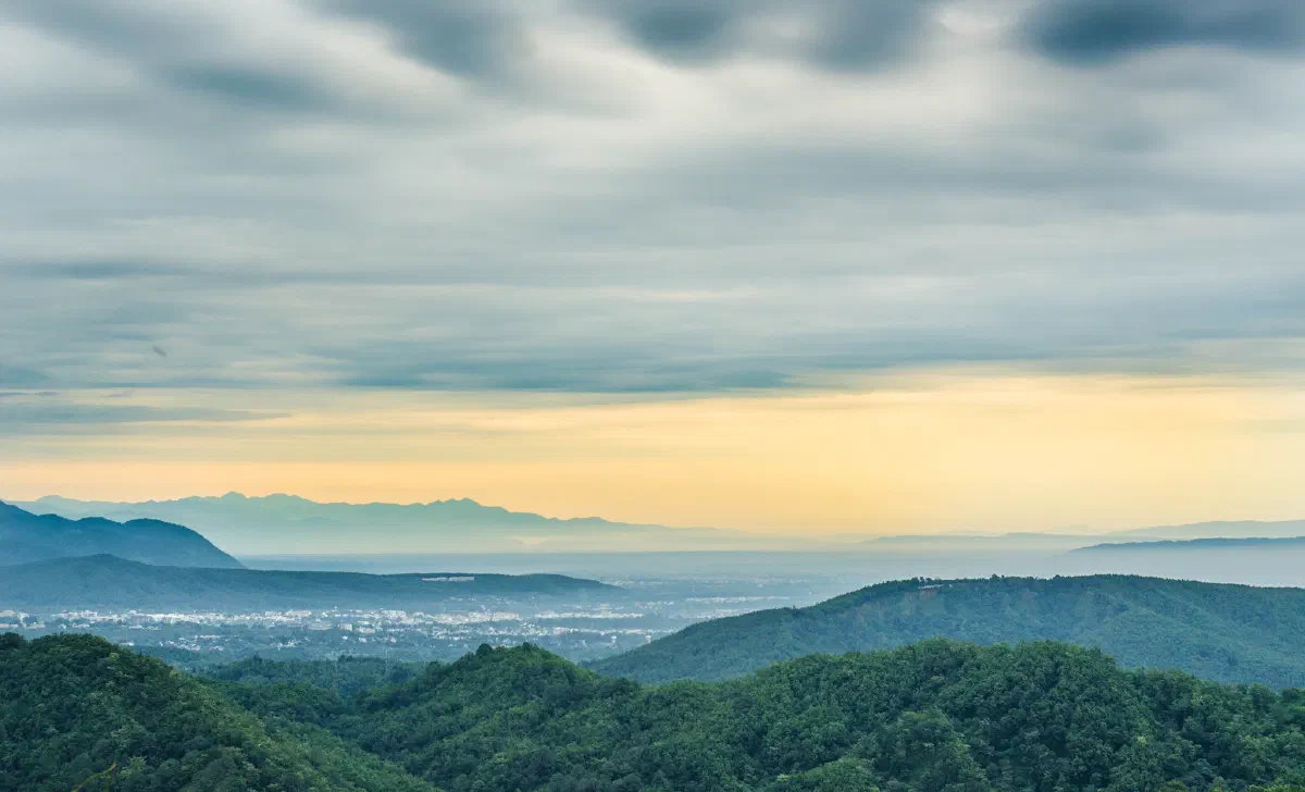 Forested hills around Dehradun under a cloudy sky